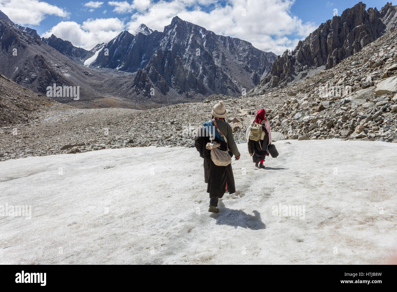 Tibetan Buddhist pilgrims crossing glacier en route Mount Kailash Kora Stock Photo