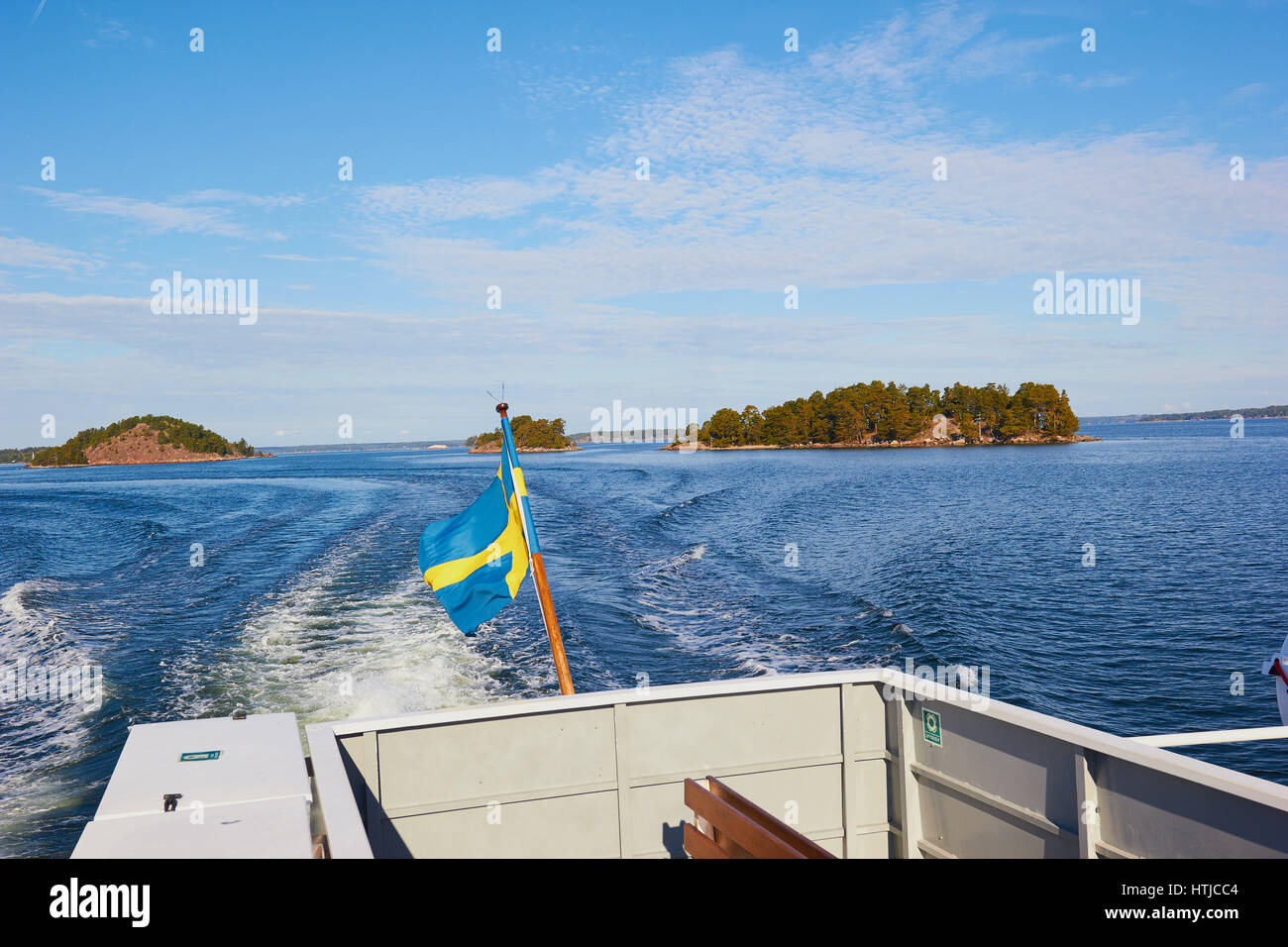 Stockholm archipelago islands seen from speeding boat with Swedish flag