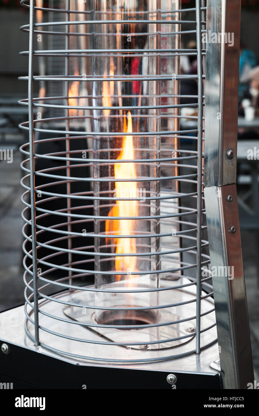 Outdoor gas heater burns on restaurant terrace Stock Photo