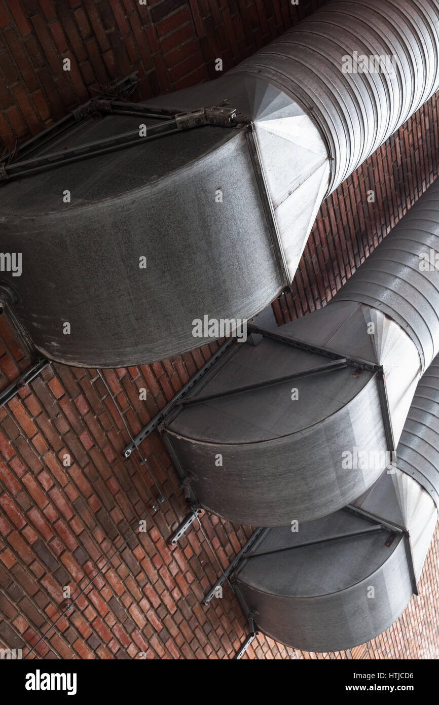Outdoor ventilation tubes mounted on red brick wall Stock Photo