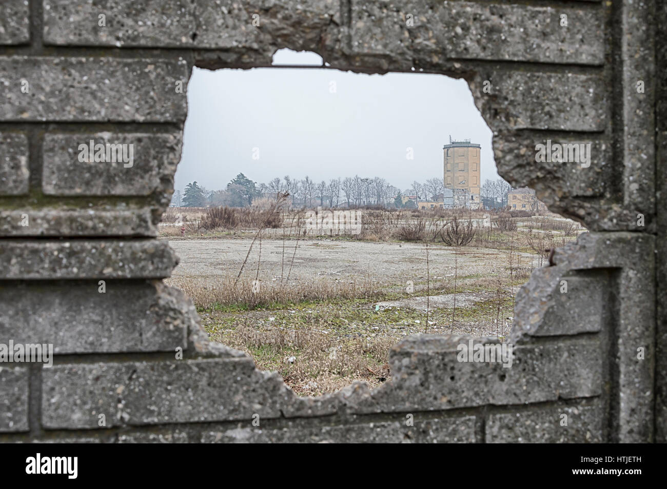 Ruins of an old factory in a wasteland, view through broken wall Stock Photo