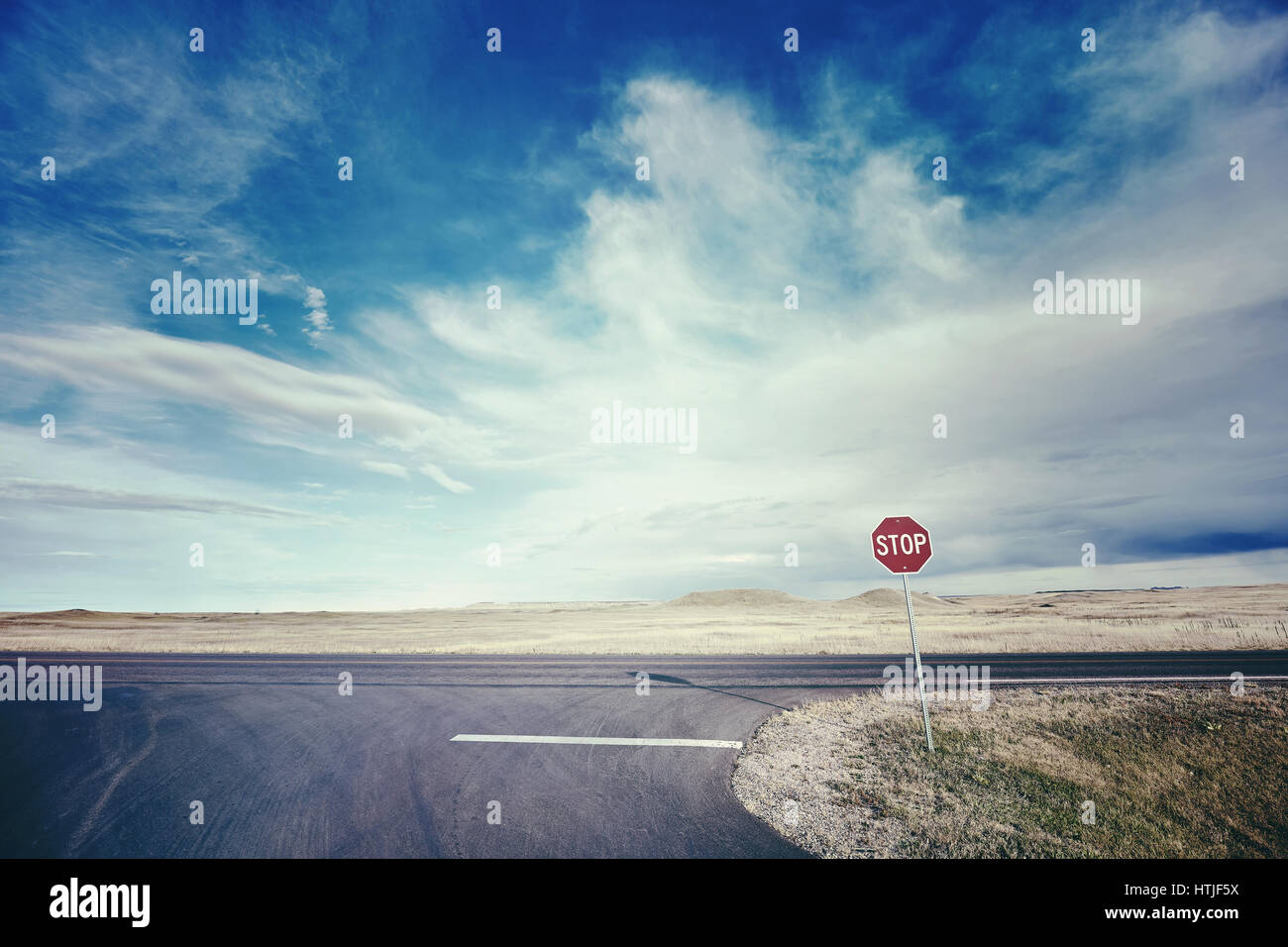 Retro stylized picture of a highway with a stop sign, USA. Stock Photo