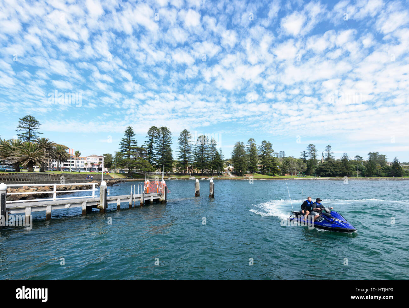 Two persons on a jetski in Kiama harbour, a scenic small coastal and touristic town on the Illawarra Coast, New South Wales, NSW, Australia Stock Photo