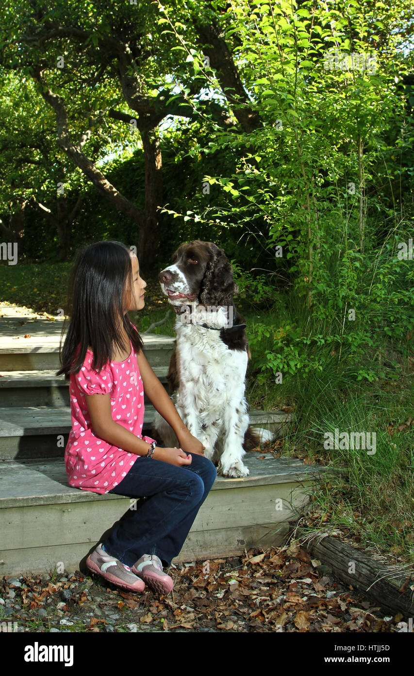 Girl sitting with her dog in the sunlight Stock Photo - Alamy