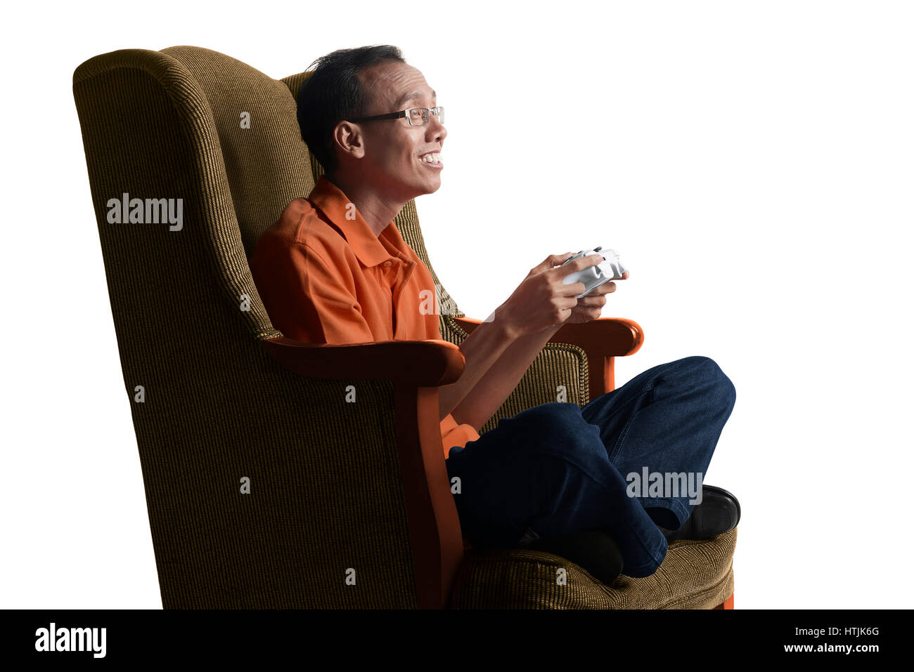 Attractive asian nerd man playing game with gamepad on sofa at home Stock Photo