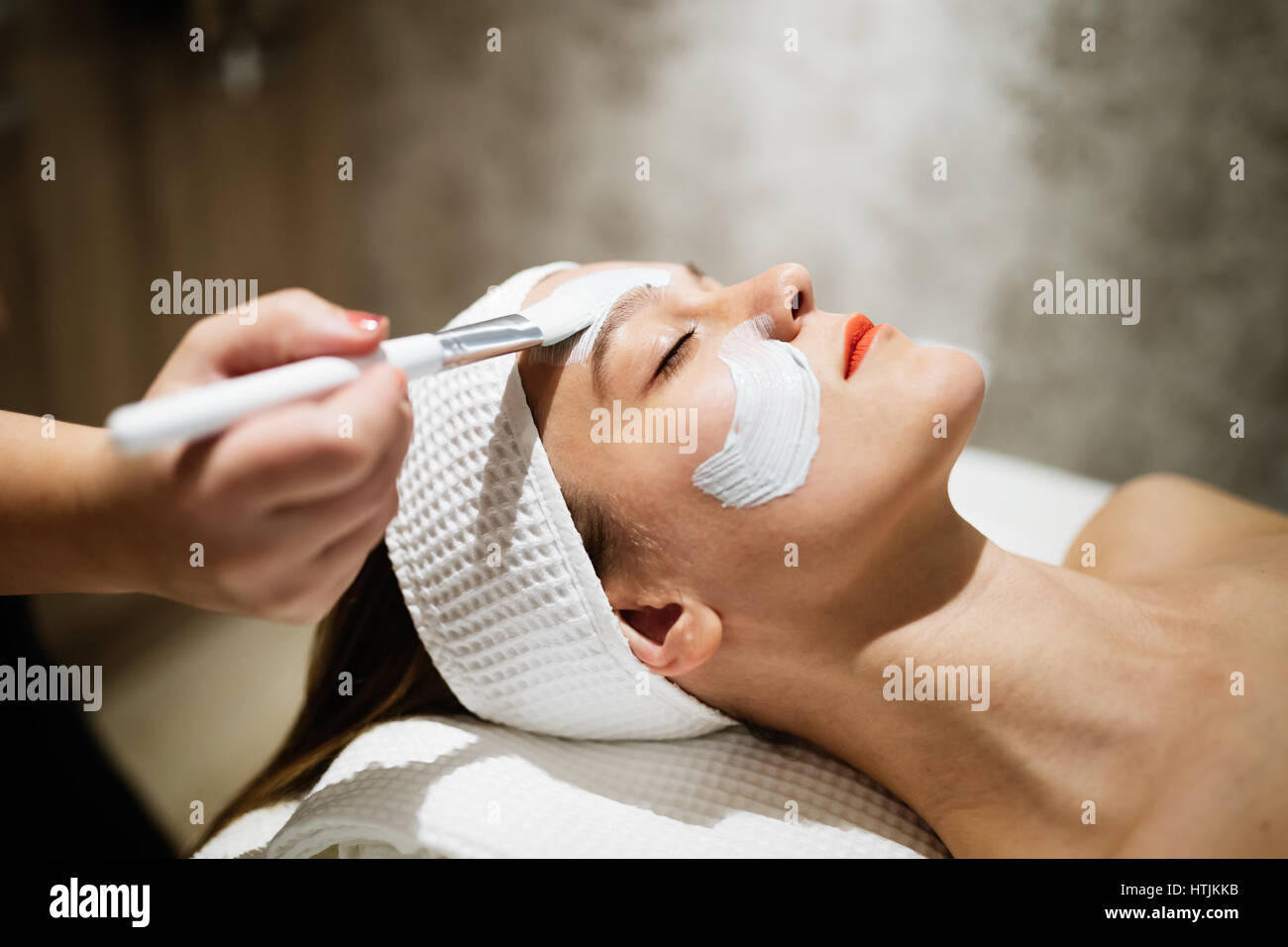 Masseur applying face mask as beauty treatment Stock Photo