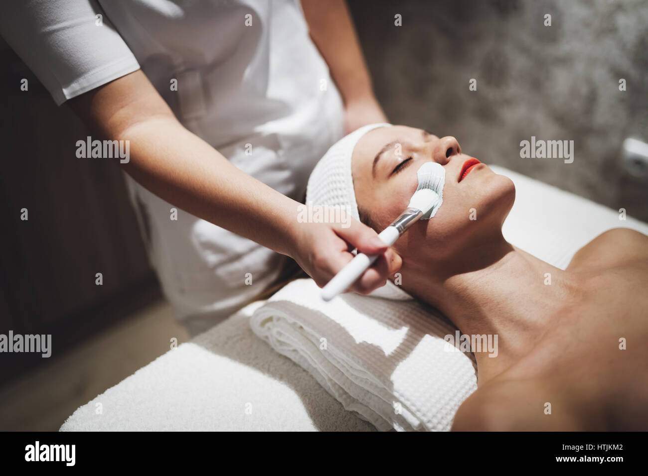 Masseur applying face mask as beauty treatment Stock Photo