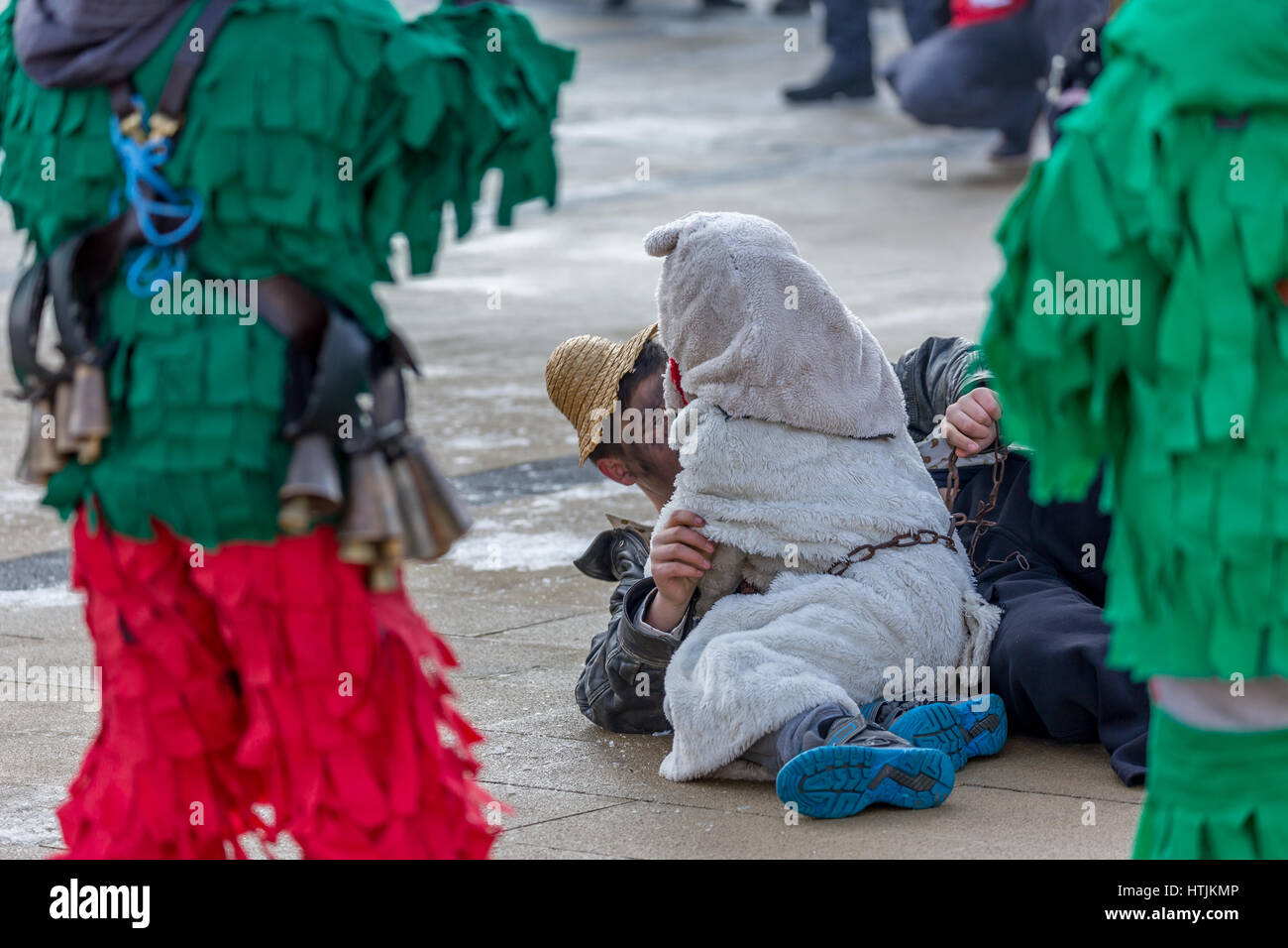 PERNIK, BULGARIA - JANUARY 27, 2017: Masked participants are fighting on the ground in ritual games at Surva, the International Festival of the Masque Stock Photo