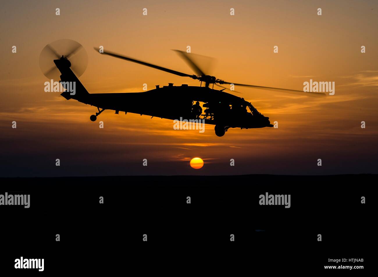 A U.S. Navy MH-60 Seahawk helicopter silhouetted against the sunset outside of Camp Buehring January 16, 2017 in Udari, Kuwait.        (photo by MCS2 Corbin J. Shea /US Navy  via Planetpix) Stock Photo