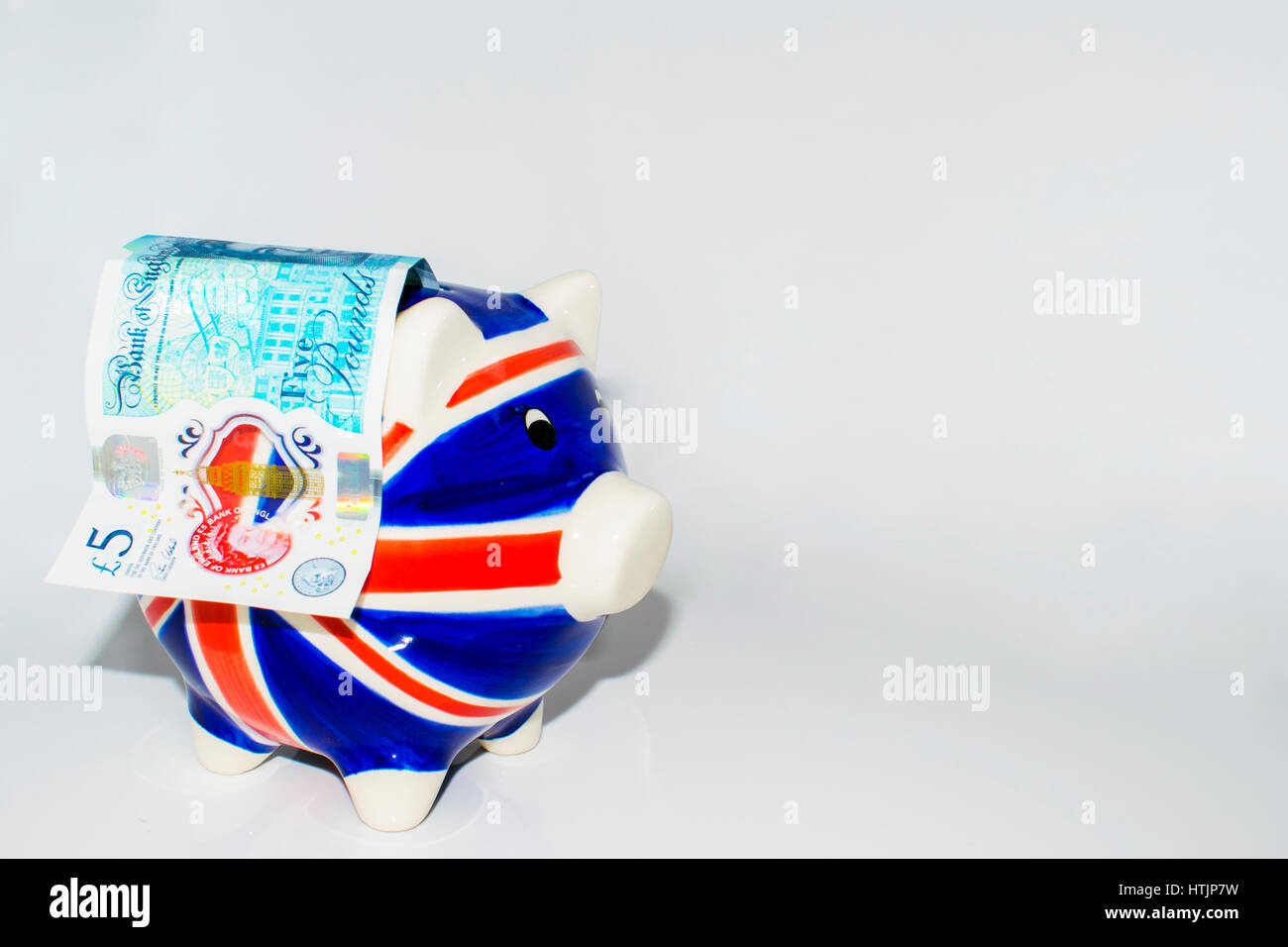 New five pount note, piggy bank - Union Jack Stock Photo