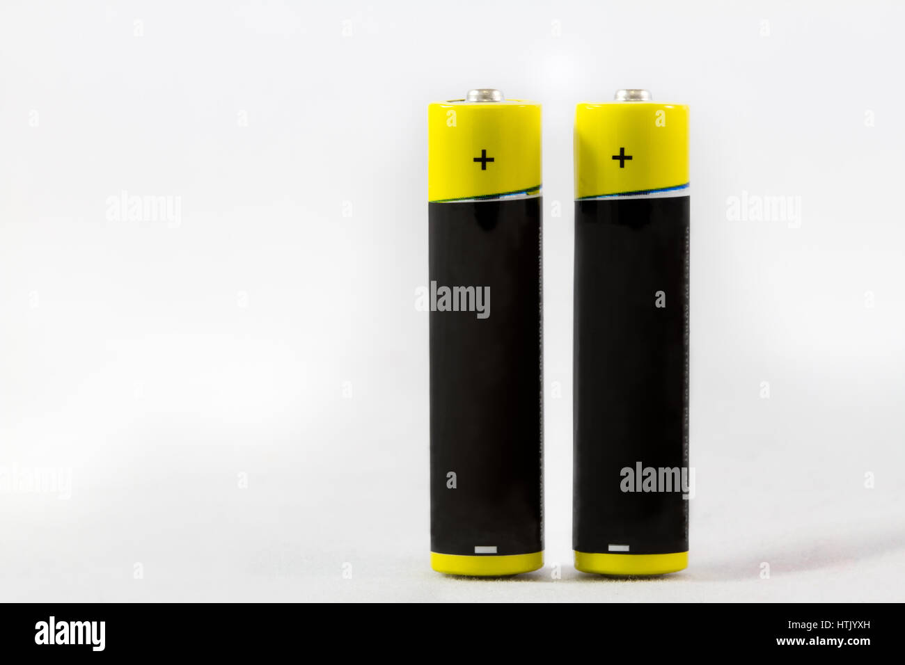 Two standing yellow black AAA alkaline batteries isolated on a white