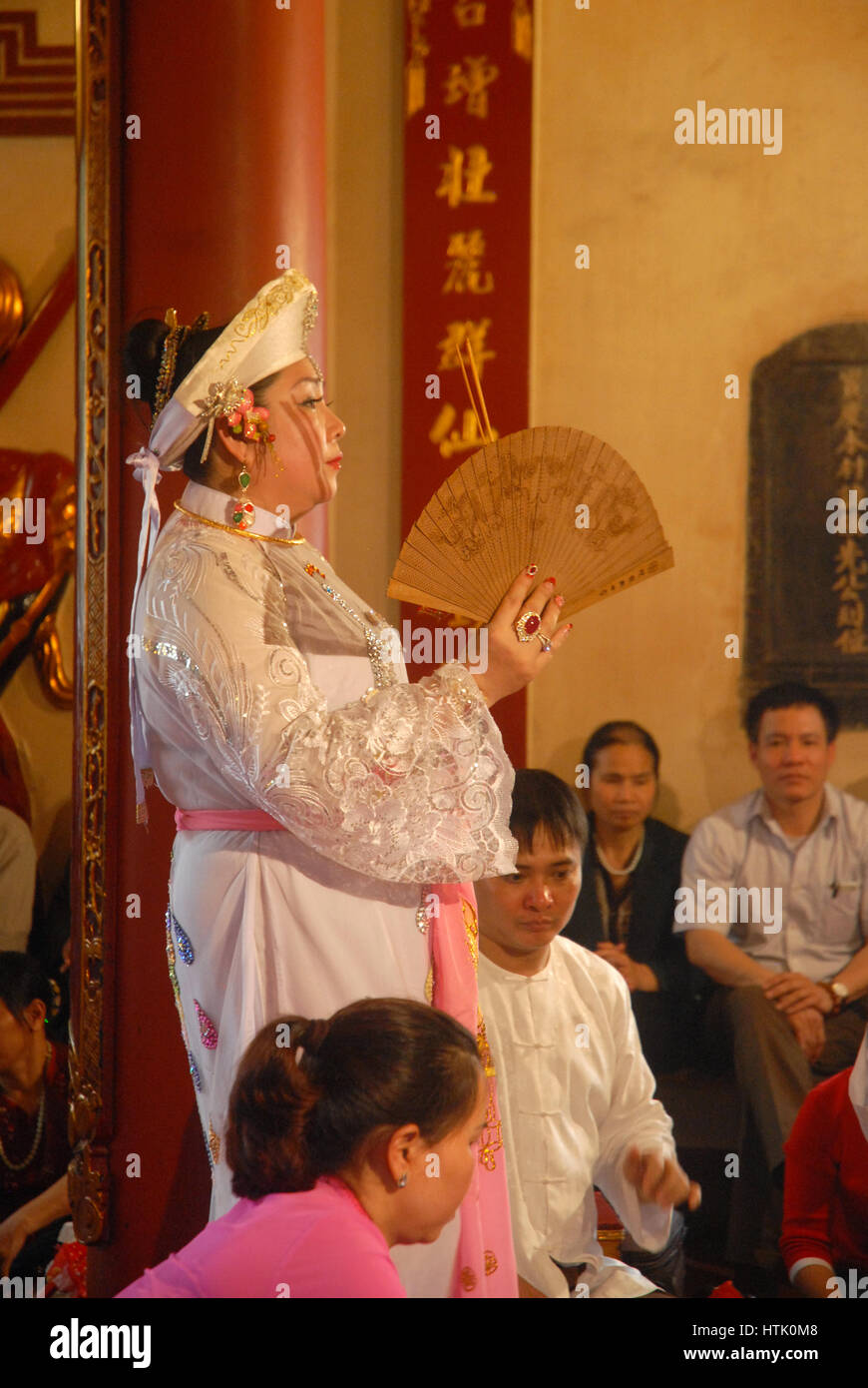 High Priestess handing out offerings in a temple, Hanoi, Vietnam. Stock Photo