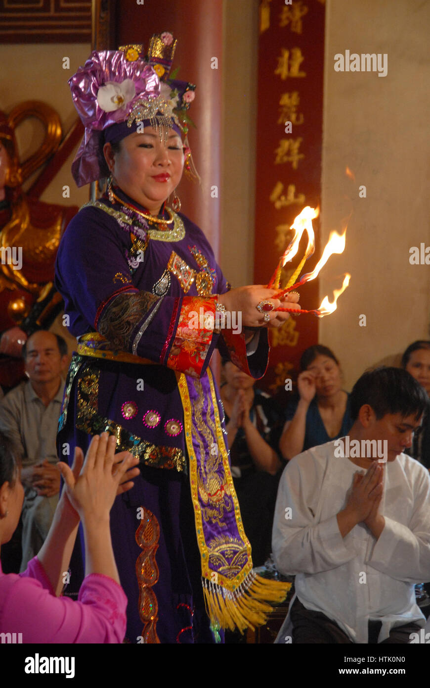 High Priestess handing out offerings in a temple, Hanoi, Vietnam. Stock Photo