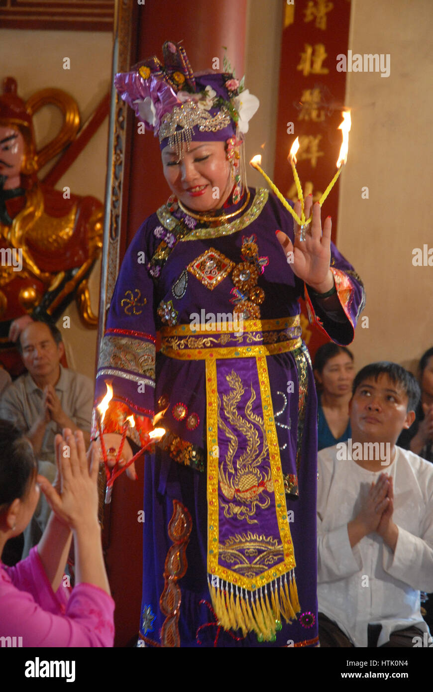 High Priestess handing out offerings in a temple, Hanoi, Vietnam. Stock Photo