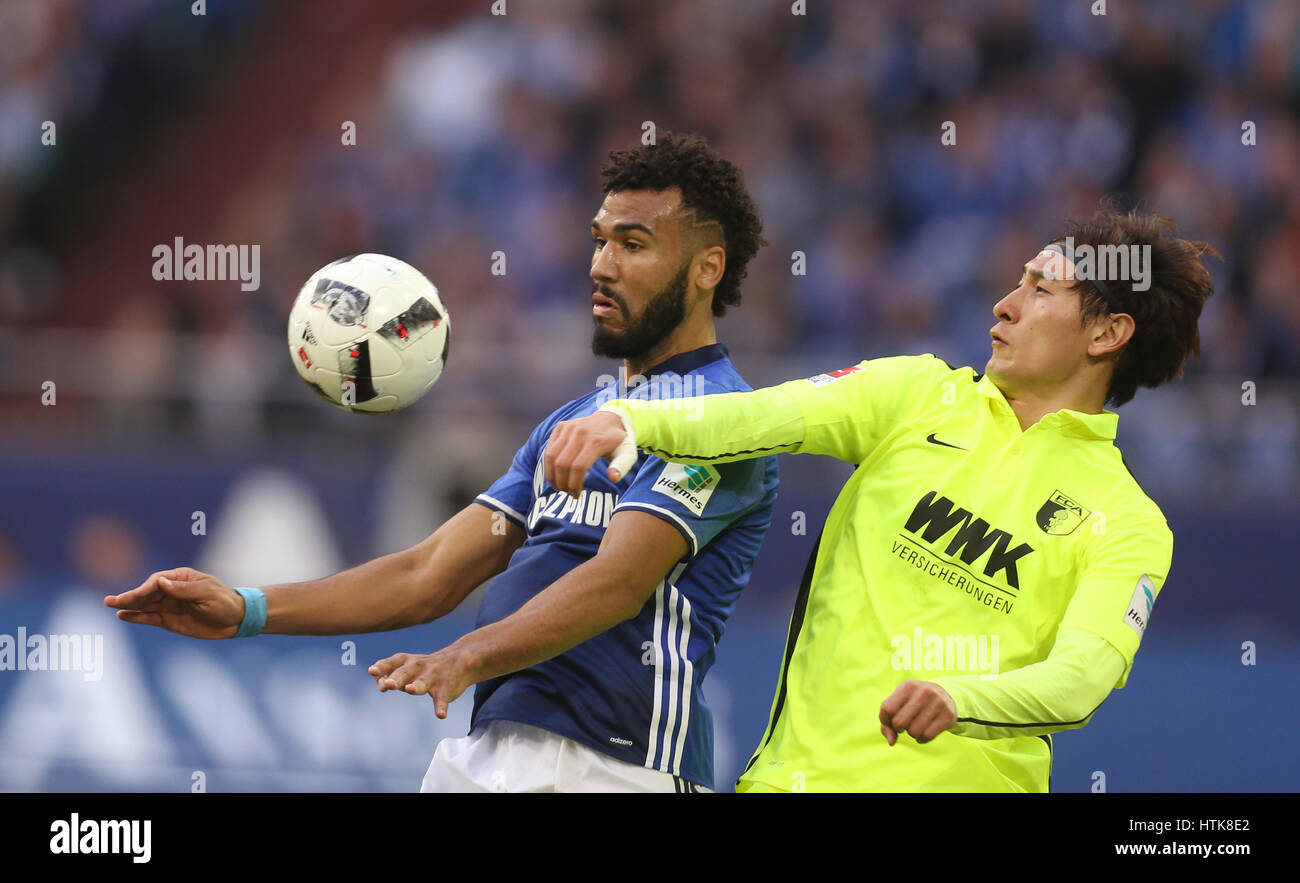 Gelsenkirchen, Germany. 12th Mar, 2017. Augsburg's Dong-Won Ji and Schalke's Eric Maxim Choupo-Moting (l) in action during the Bundesliga soccer match between FC Schalke 04 and FC Augsburg at the Veltins Arena in Gelsenkirchen, Germany, 12 March 2017. (EMBARGO CONDITIONS - ATTENTION: Due to the accreditation guidlines, the DFL only permits the publication and utilisation of up to 15 pictures per match on the internet and in online media during the match.) Photo: Ina Fassbender/dpa/Alamy Live News Stock Photo