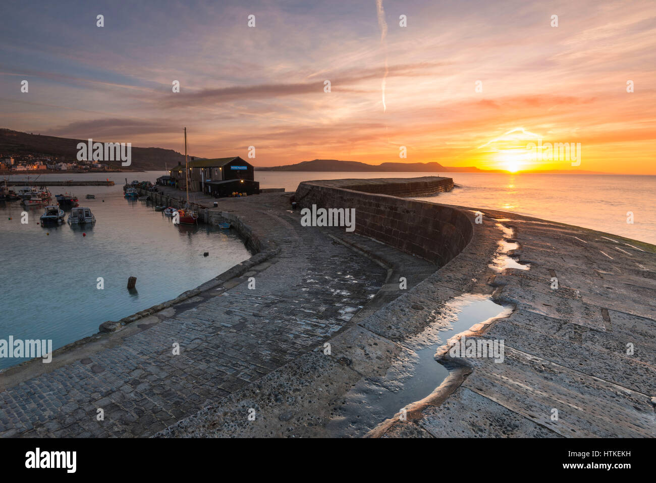 Lyme Regis, Dorset, UK.  13th March 2017.  UK Weather. A glorious spring sunrise viewed from the historic Cobb harbour wall at the seaside resort of Lyme Regis on the Dorset Jurassic Coast.  Photo by Graham Hunt/Alamy Live News Stock Photo
