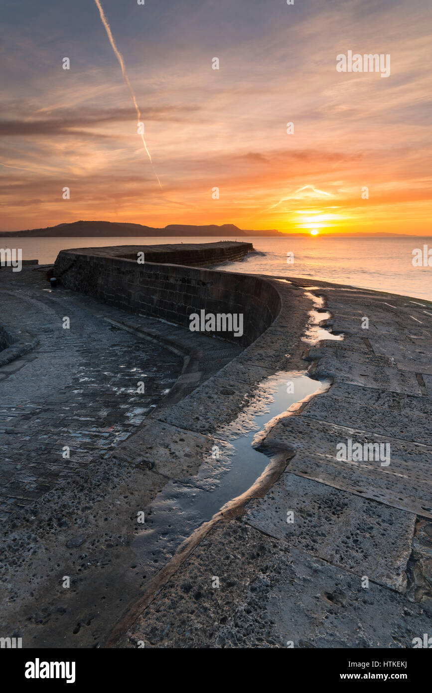 Lyme Regis, Dorset, UK.  13th March 2017.  UK Weather. A glorious spring sunrise viewed from the historic Cobb harbour wall at the seaside resort of Lyme Regis on the Dorset Jurassic Coast.  Photo by Graham Hunt/Alamy Live News Stock Photo