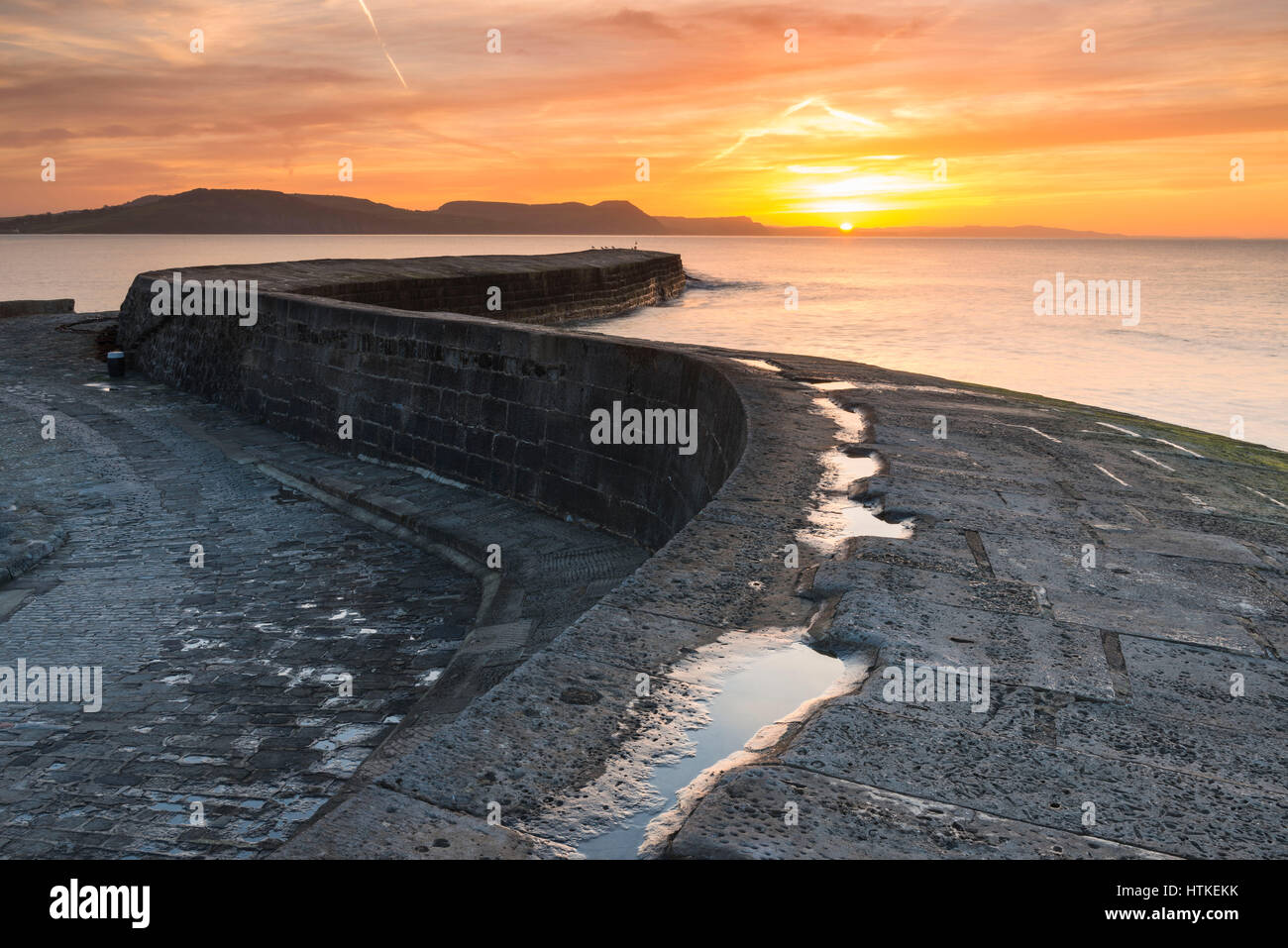 Lyme Regis, Dorset, UK.  13th March 2017.  UK Weather. A glorious spring sunrise viewed from the historic Cobb harbour wall at the seaside resort of Lyme Regis on the Dorset Jurassic Coast.  Photo by Graham Hunt/Alamy Live News Stock Photo