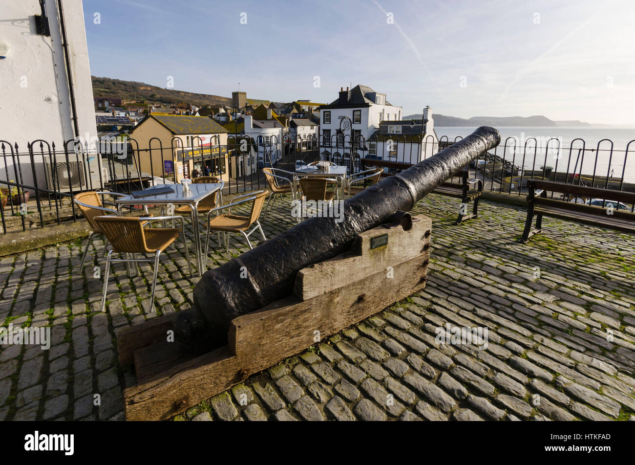 Lyme Regis, Dorset, UK.  13th March 2017.  UK Weather. Beautiful warm spring sunshine and blues skies during the morning at the seaside resort of Lyme Regis on the Dorset Jurassic Coast.  The view is of the cannon at Bell Cliff above Cobb Gate at the bottom of Broad Street.  Photo by Graham Hunt/Alamy Live News Stock Photo