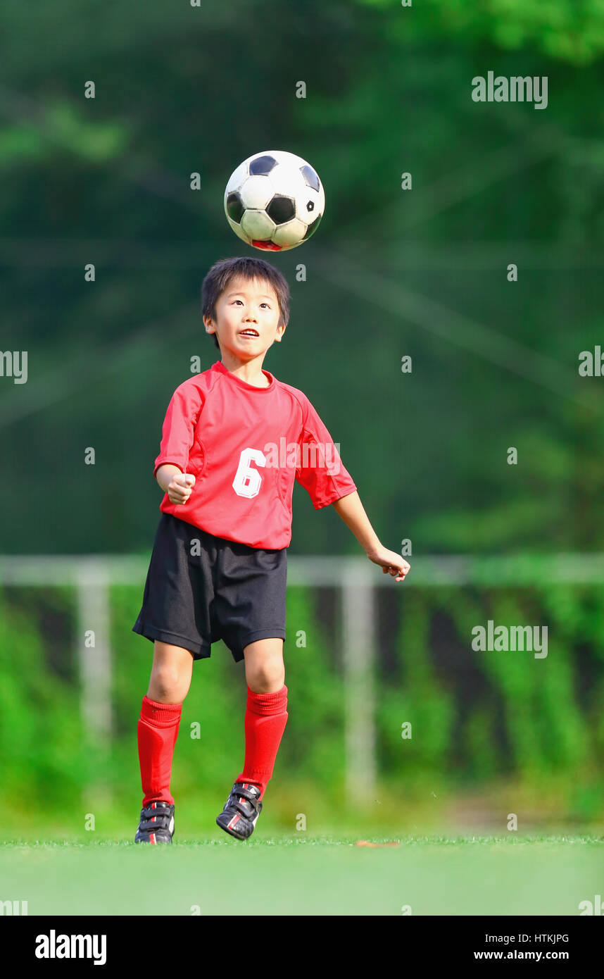 Japanese kid playing soccer Stock Photo