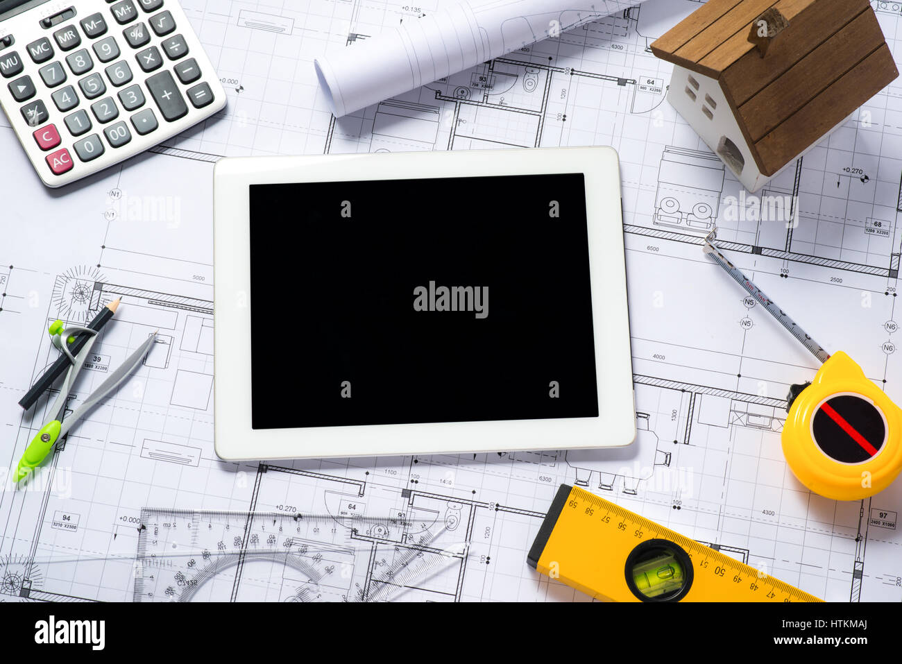 digital tablet with architectural blueprints rolls and tools Stock Photo