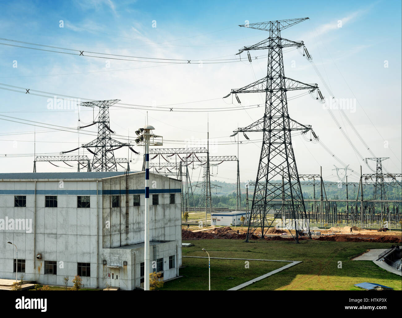 Electricity pylon against blue cloudy sky Stock Photo - Alamy