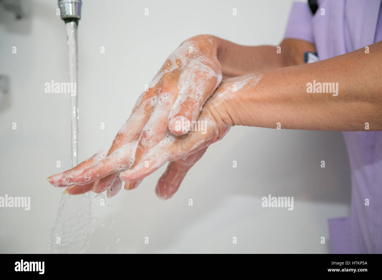 Washing hands with soapy water in clinical setting Stock Photo