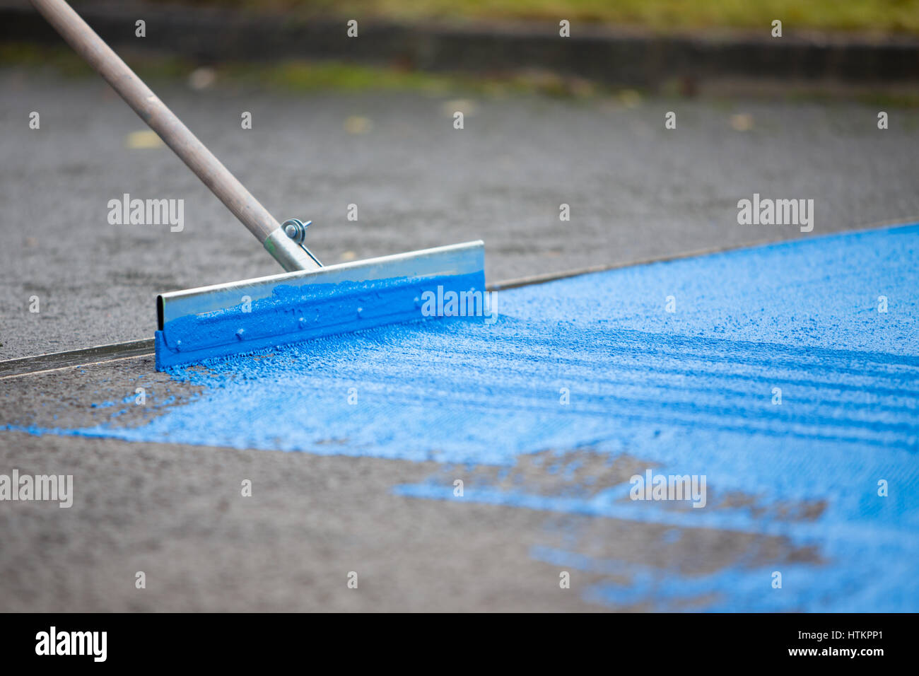 Applying blue raod surface paint Stock Photo