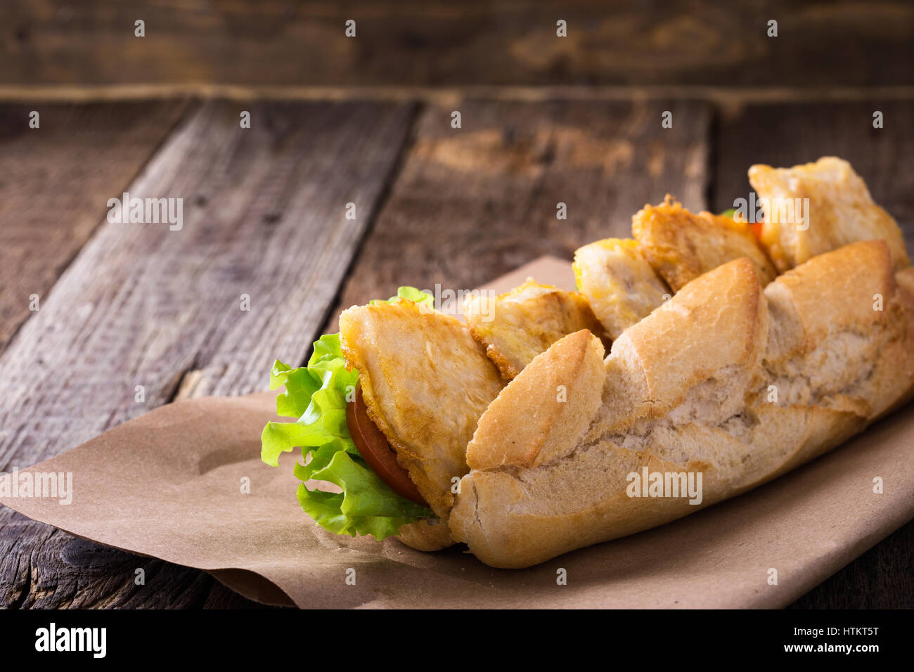 Homemade fried fish sandwich. Fried catfish po boy on rustic wooden table Stock Photo