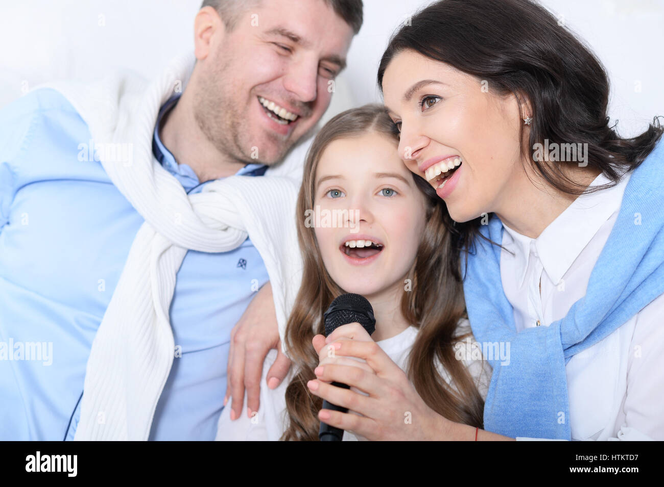 Portrait of a family with daughter singing karaoke Stock Photo Alamy