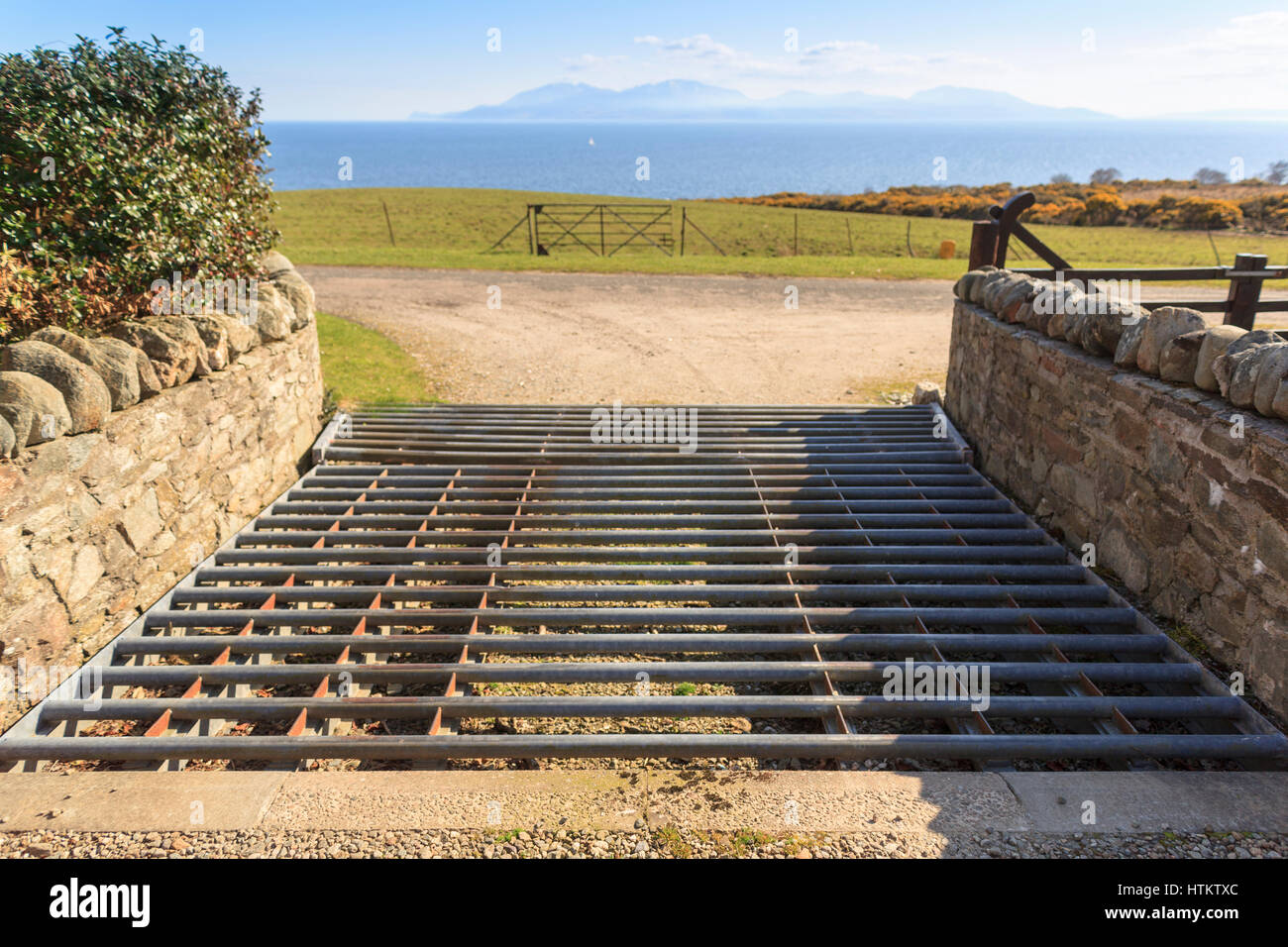 Property cattle grid or cattle guard entrance or exit onto public road in rural countryside area  Model Release: No.  Property Release: No. Stock Photo