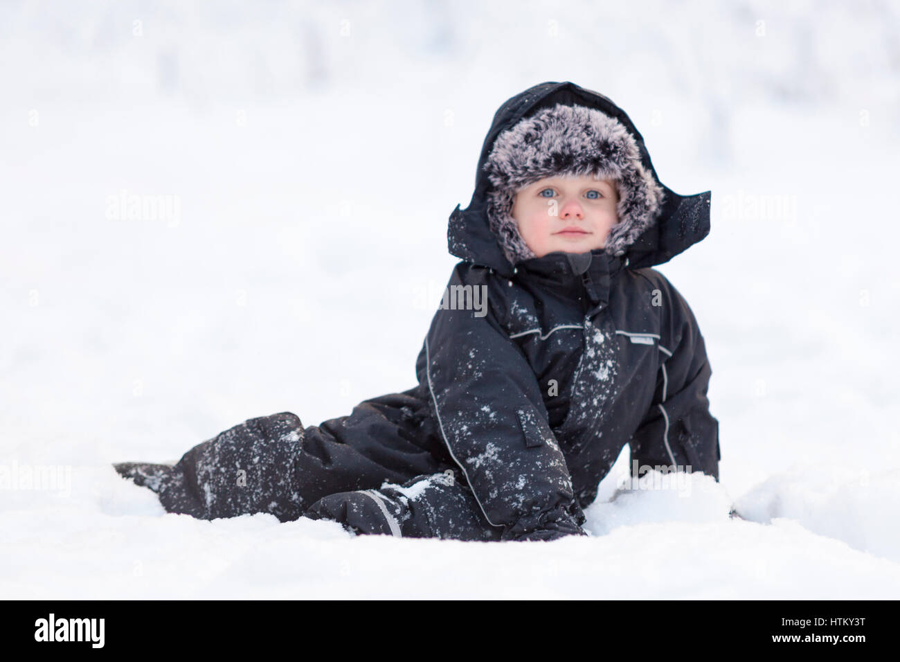 Young boy in warm winter thermal suit clothing outdoor portrait in