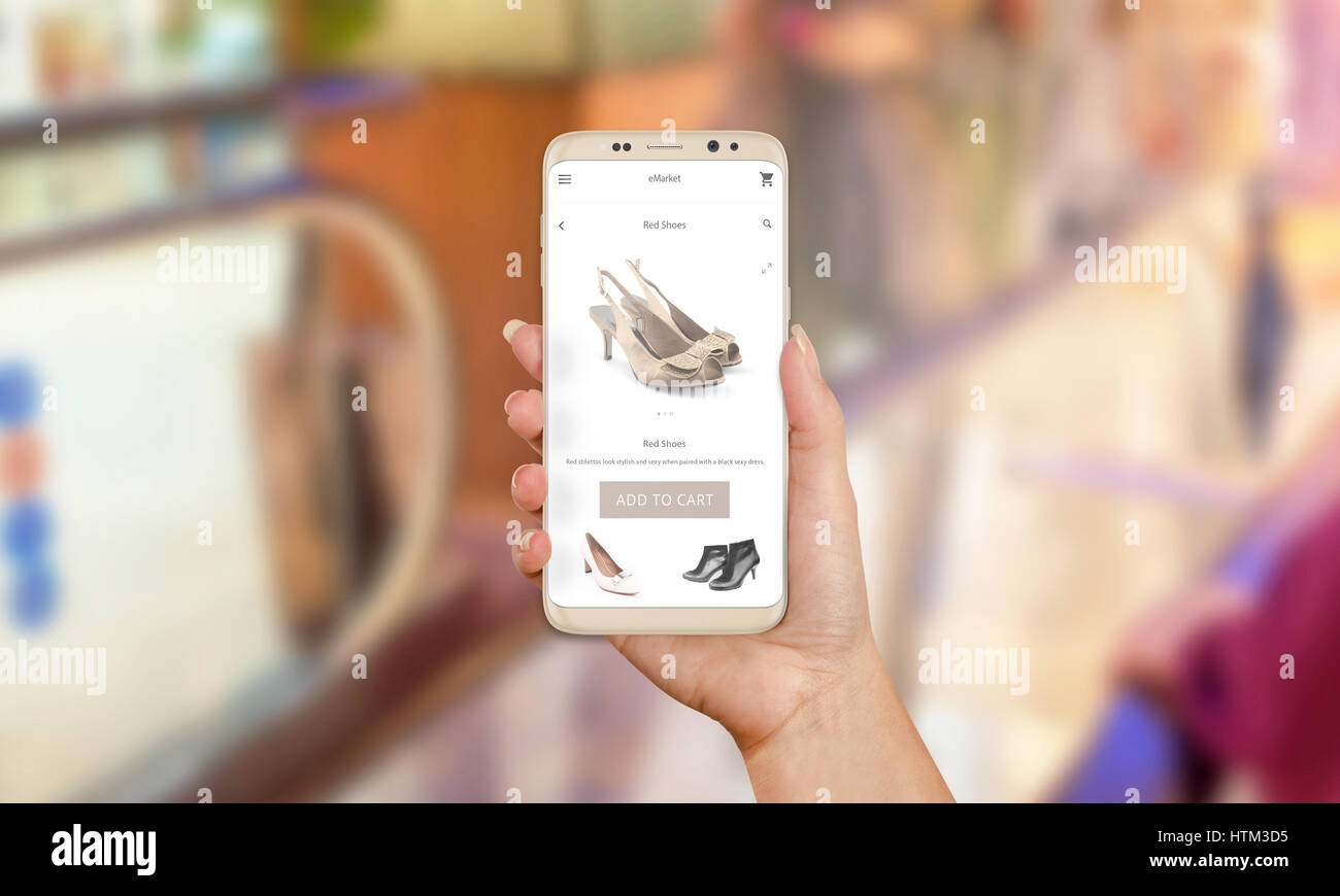 Woman buy shoes online with mobile phone app. Purchase of modern dress shoes. Buy now button on mobile app. Shopping mall in background. Stock Photo