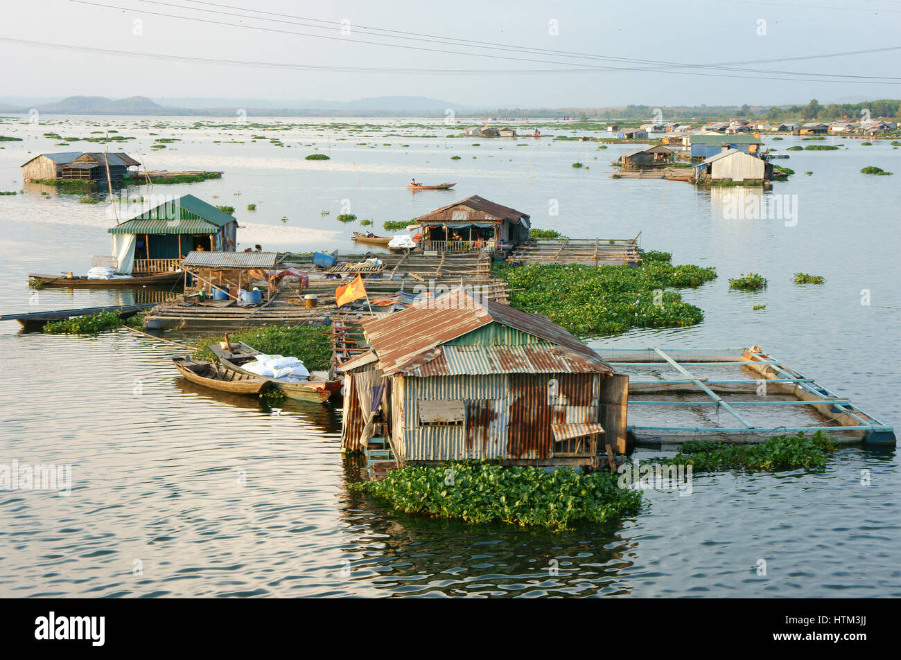 DONG NAI, VIET NAM, Life of Asian fisherman on La Nga river, floating house in residence of fishing village with aquaculture, river fish, Vietnam Stock Photo