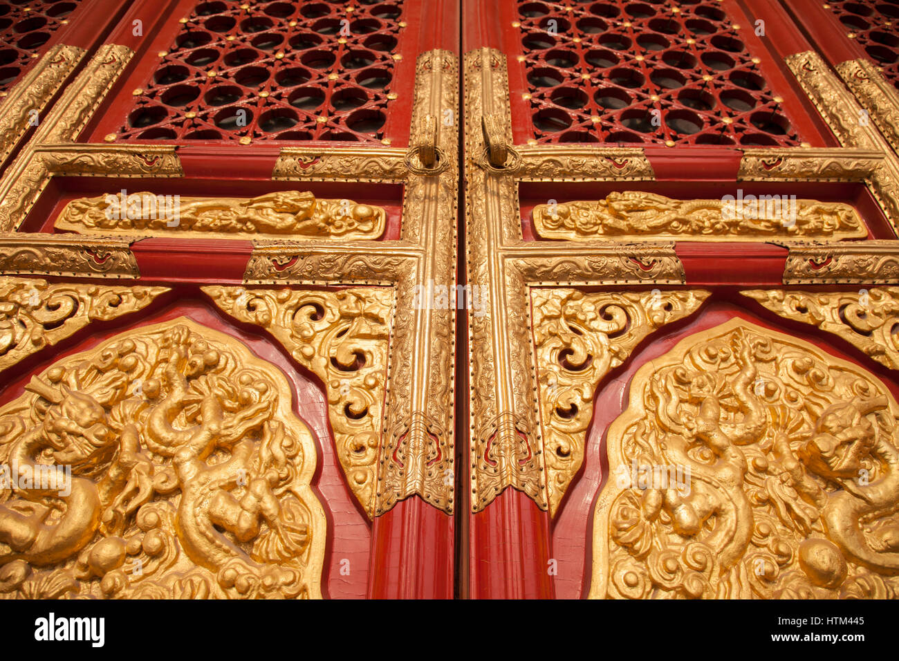 Door knob and the embossed designs of clouds and dragons on the door in the Forbidden City, Beijing, China Stock Photo