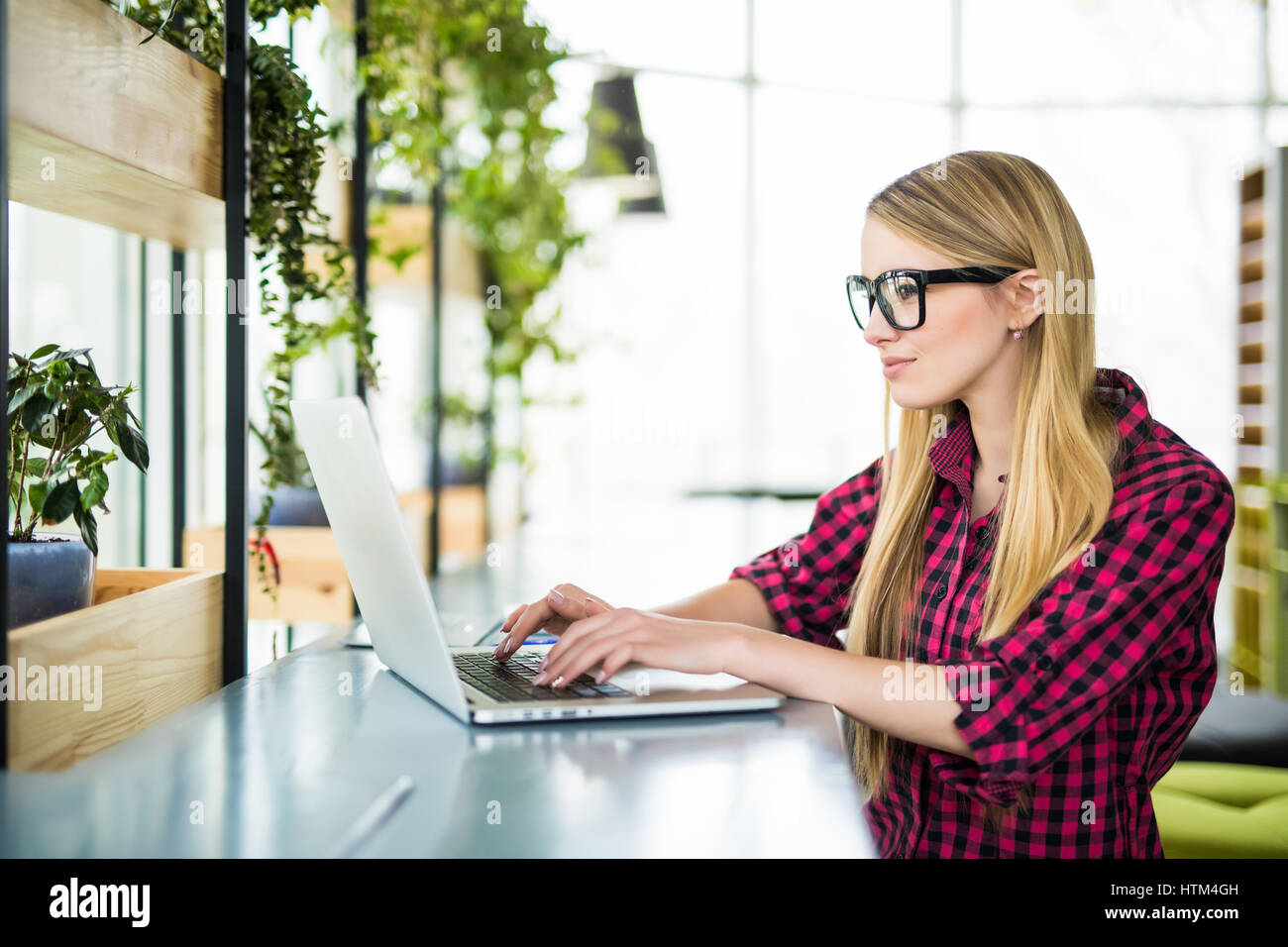 Young female entrepreneur working sitting at a desk typing on her ...