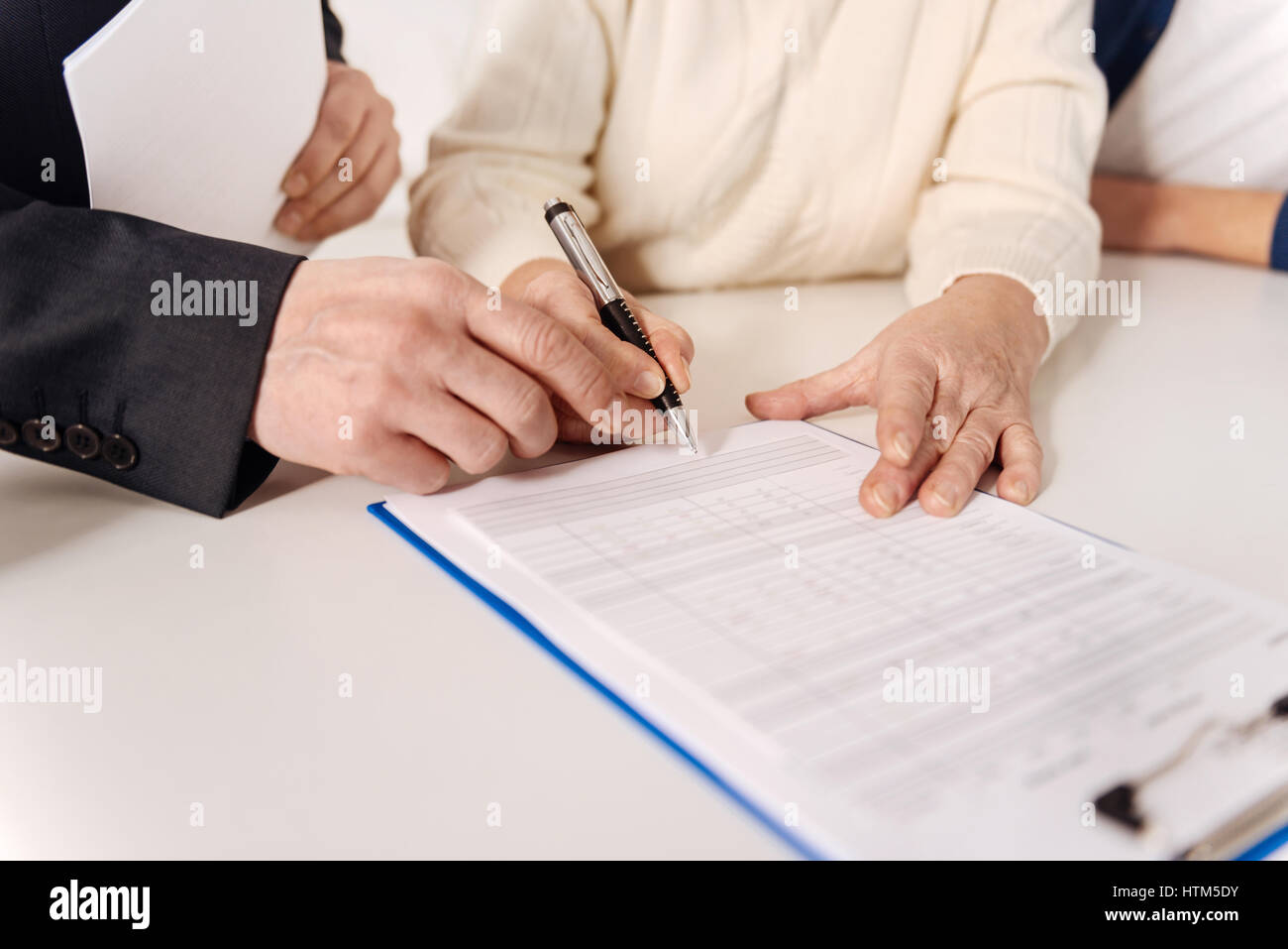 Proficient social security advisor signing document with elderly couple Stock Photo