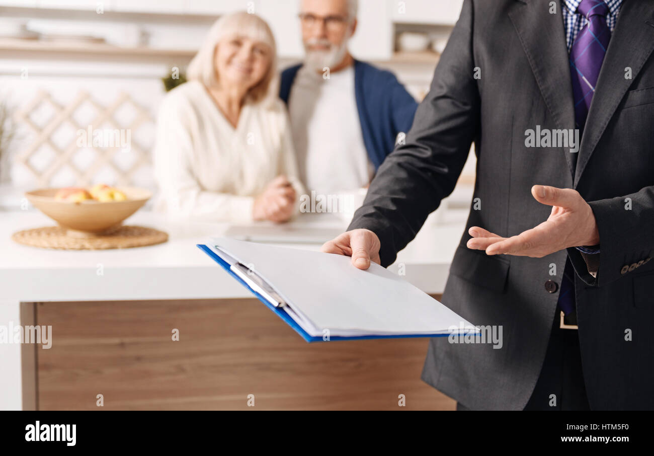 Proficient social security advisor demonstrating document for elderly couple Stock Photo