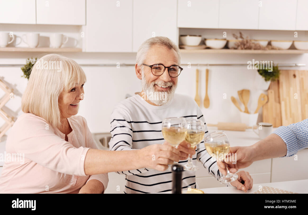 Joyful aged parents celebrating holiday with guests at home Stock Photo