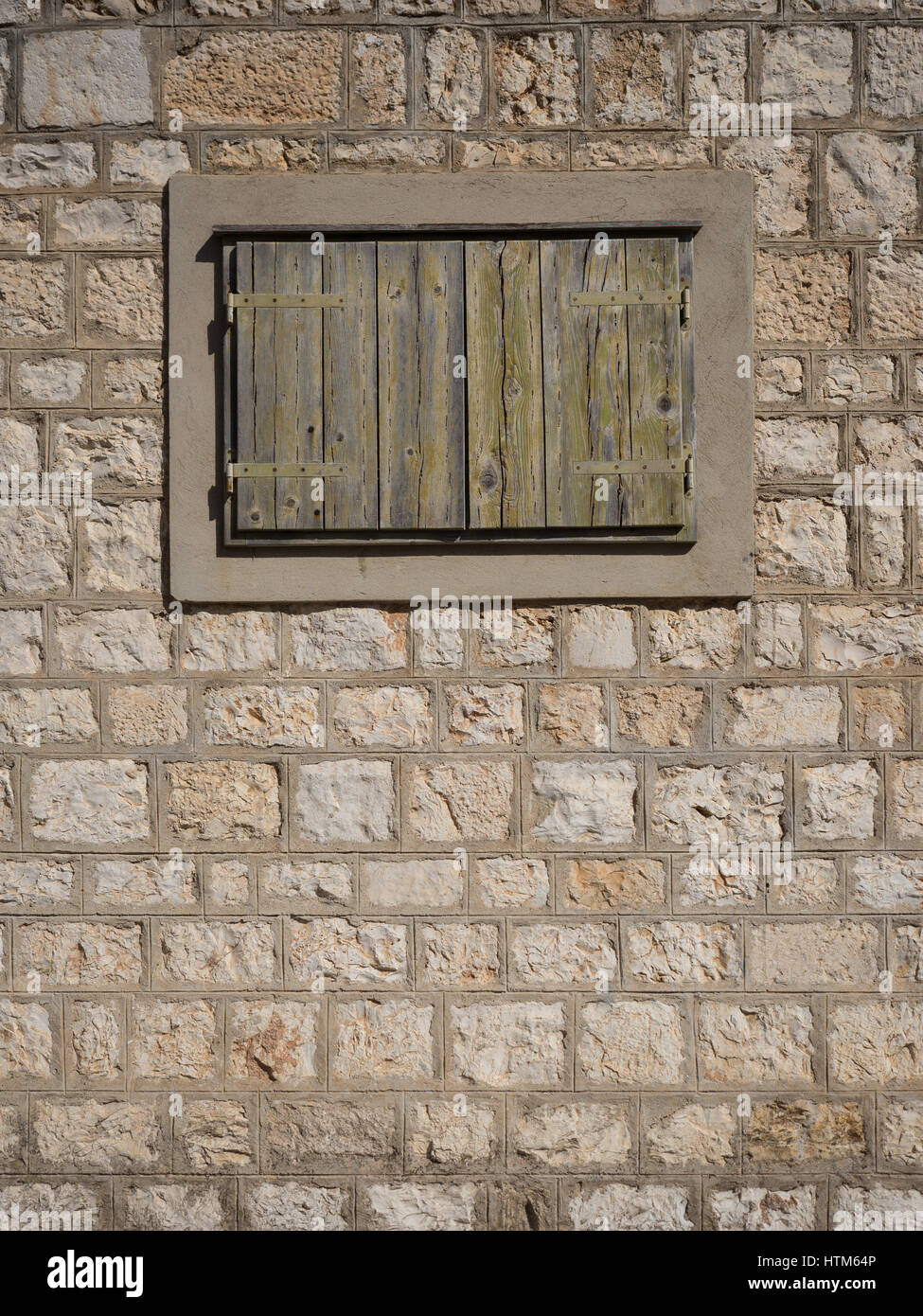 an old window with wooden wood shutter shutters in a pointed stone wall ...