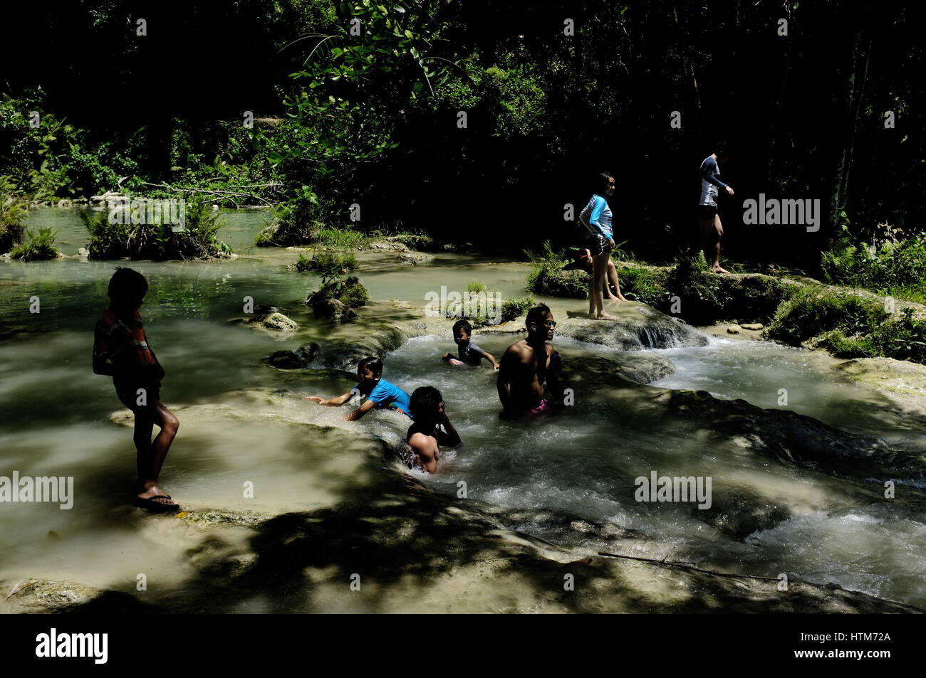 People are enjoying the Cambugahay waterfall area at Siquijor, an island province of the Philippines. Stock Photo
