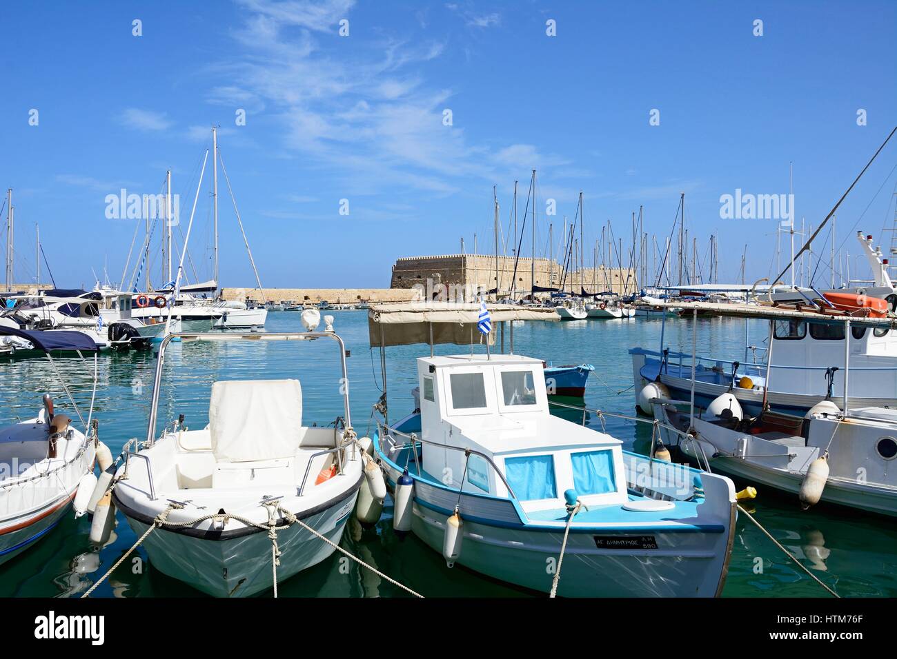 Traditional fishing boats moored in the harbour with Koules castle to the rear, Heraklion, Crete, Greece, Europe. Stock Photo