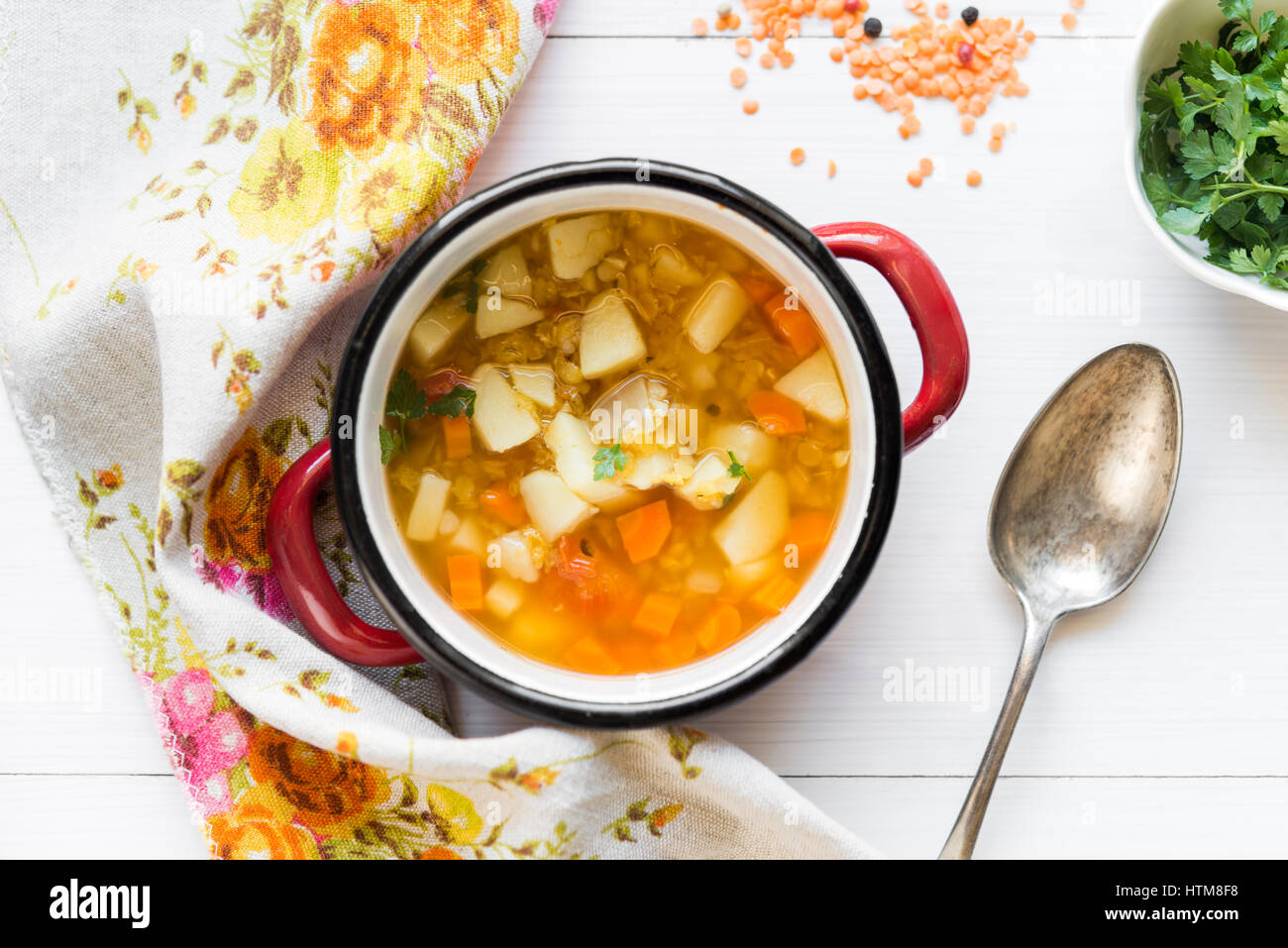Top view of vegetarian pea soup with red lentil and fresh parsley on white wooden table Stock Photo