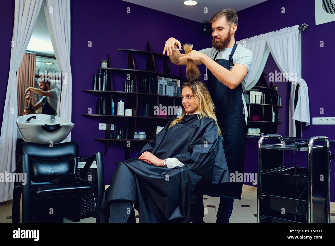 A male hairdresser does  haircut for  woman in  hair beauty salon. Stock Photo