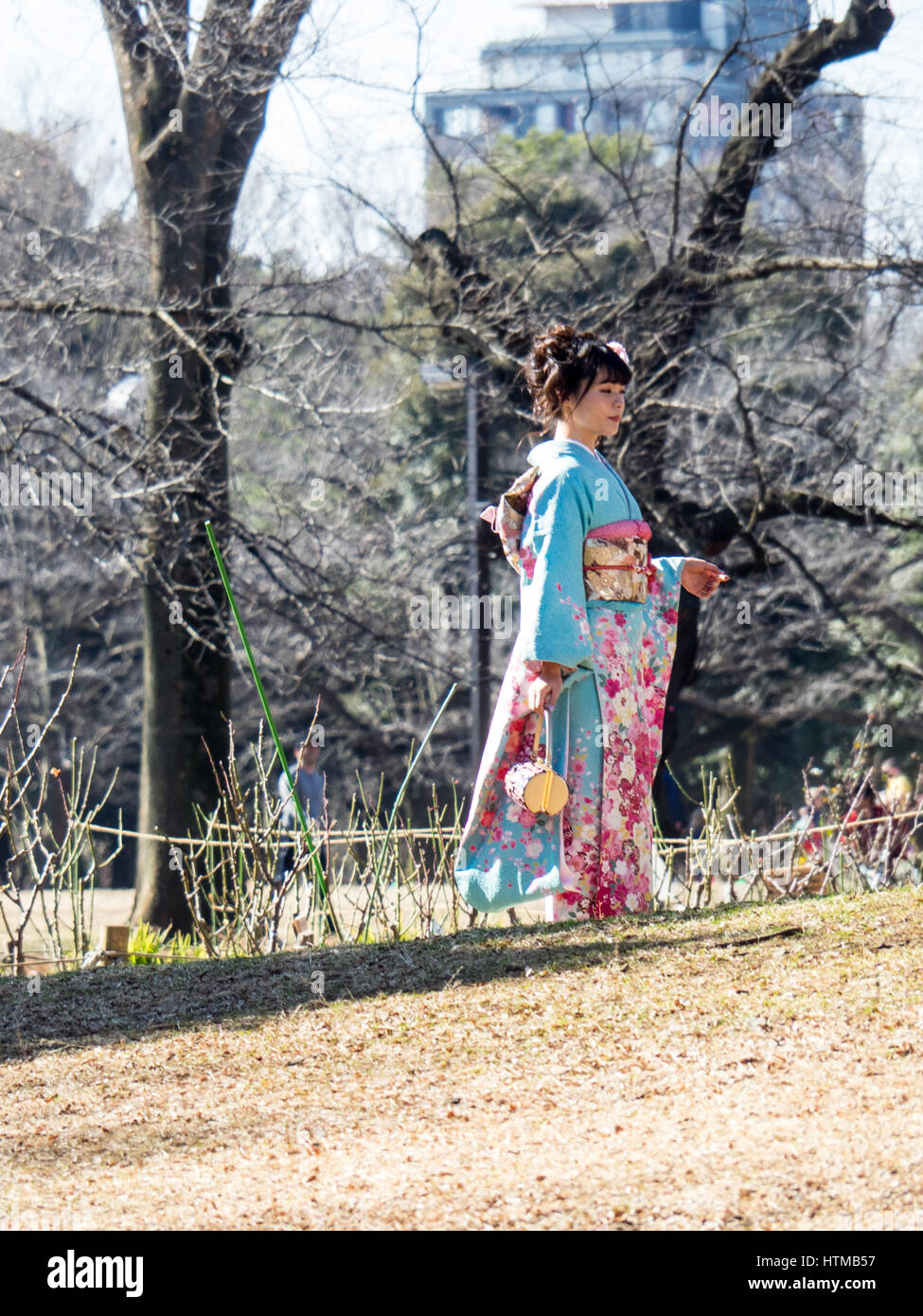 A young Japanese woman posing for a photograph in Yoyogi Park, Shibuya, Tokyo, Japan. Stock Photo