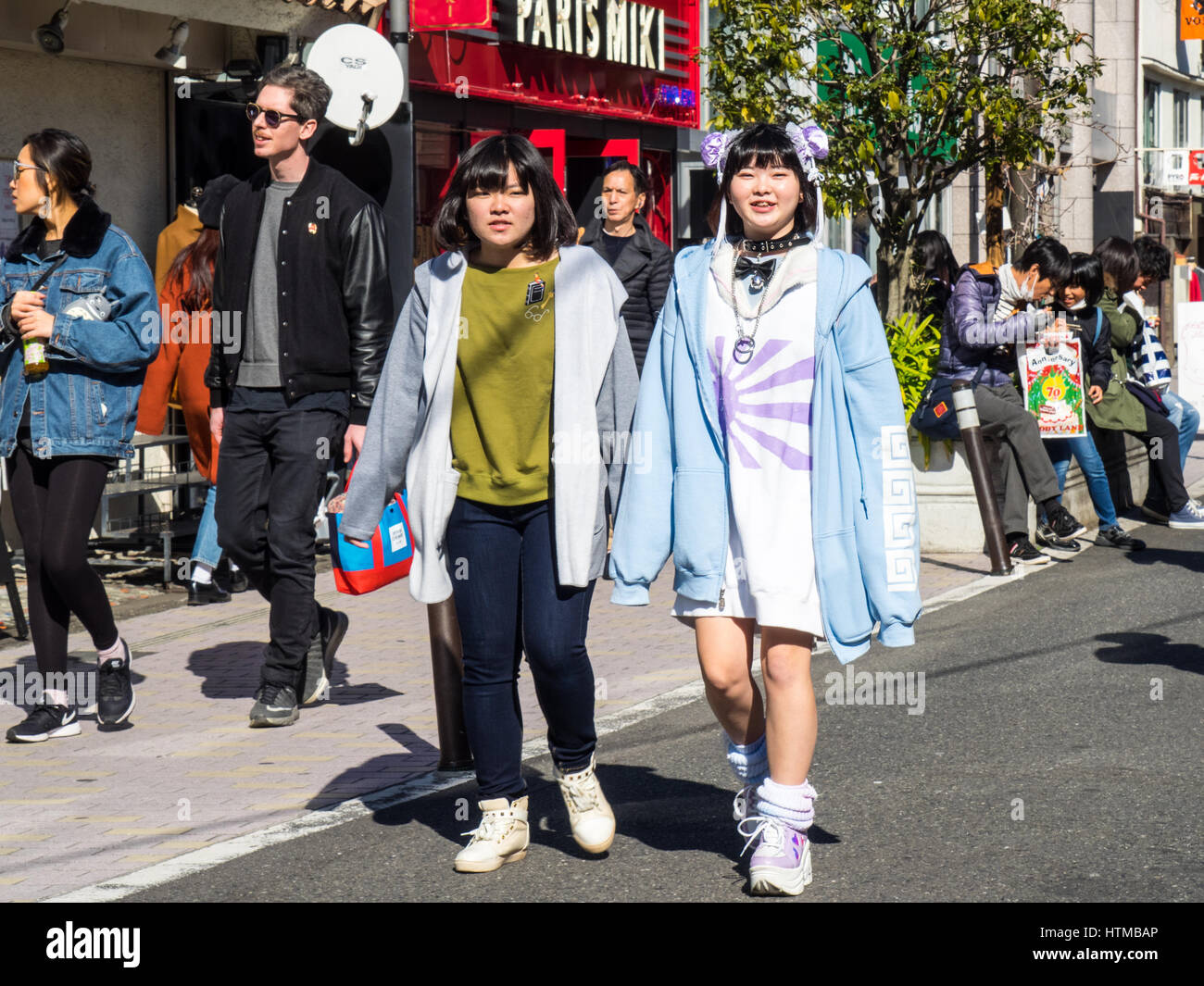 Two girls walking along a shopping street in Shibuya, Tokyo, Japan. Stock Photo