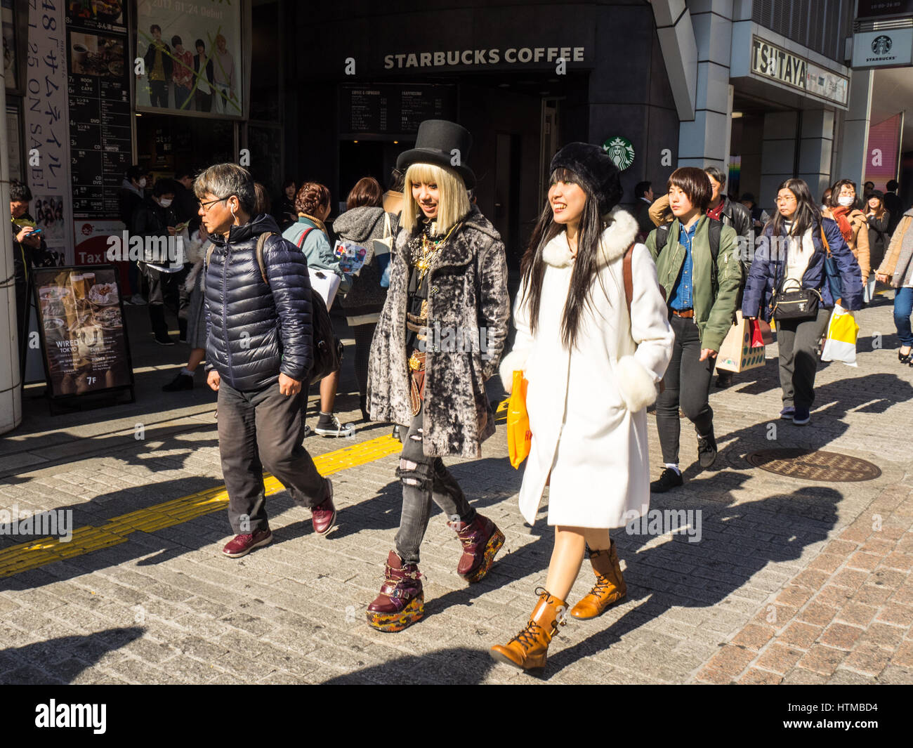 Two women in fashionable clothes walking in the Shibuya shopping district, Tokyo Japan. Stock Photo