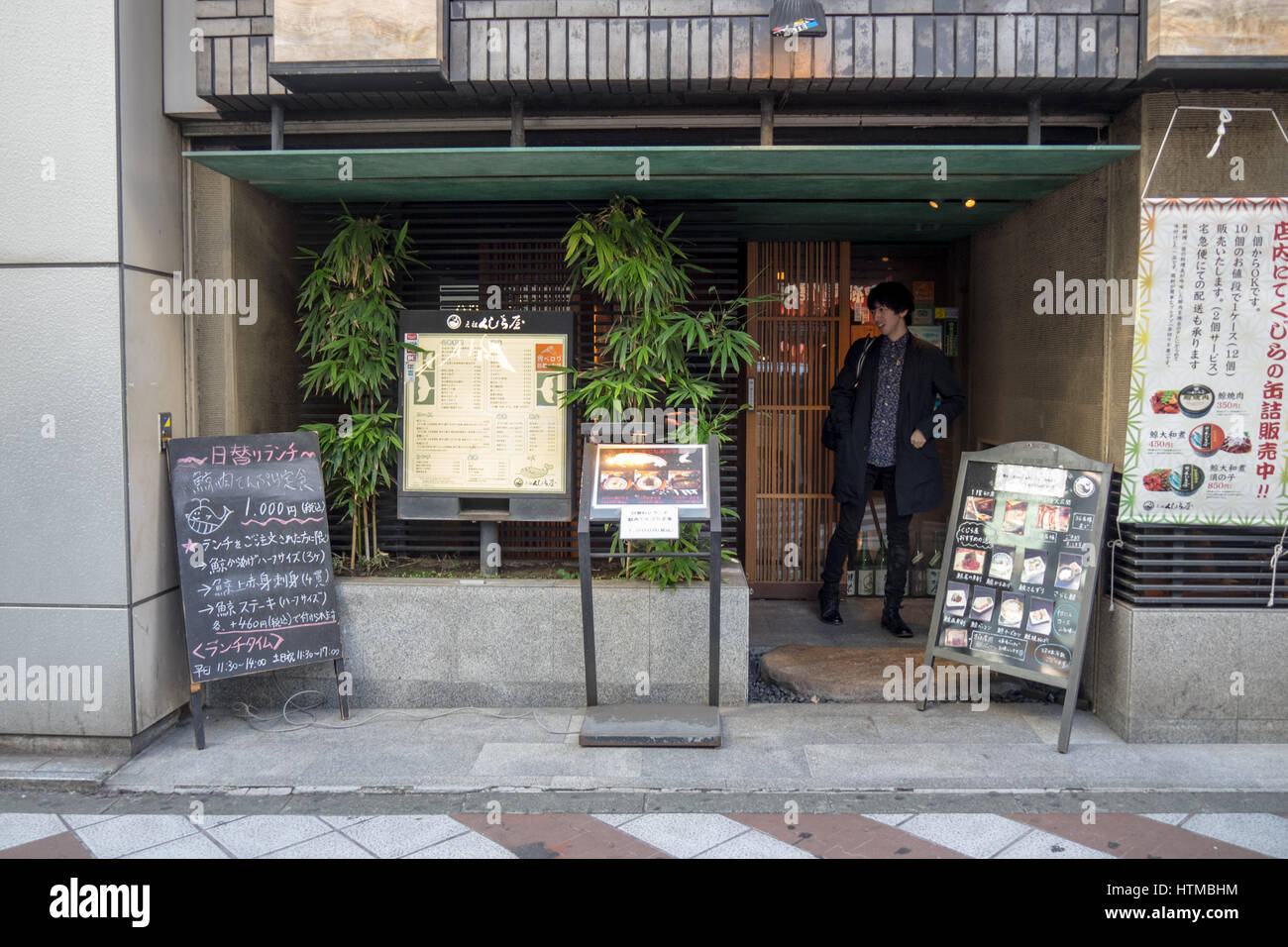A man walking out of a restaurant which serves whale meat, in Shibuya Tokyo Japan. Stock Photo