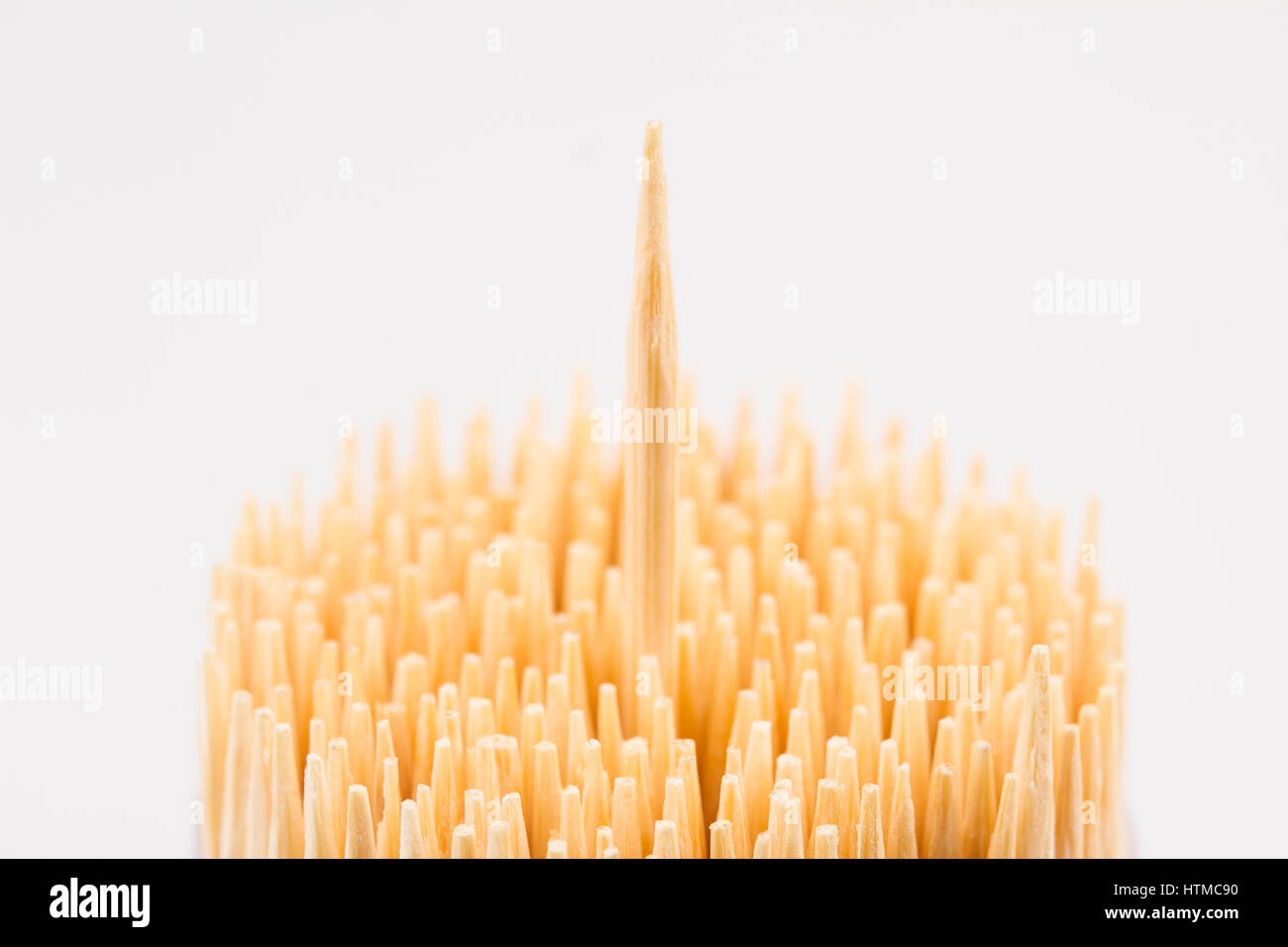 horizontal top view close up of wooden bamboo toothpicks with one stick rising up isolated on white background Stock Photo