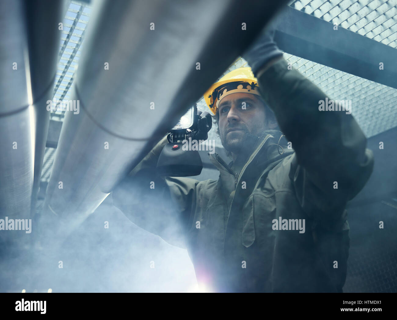 Mechanic with flashlight checking a pipeline, Austria Stock Photo Alamy